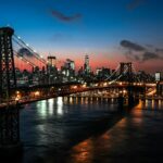 Iconic view down Washington Street in DUMBO with 19th-century brick industrial warehouses framing the Manhattan Bridge arch and Empire State Building