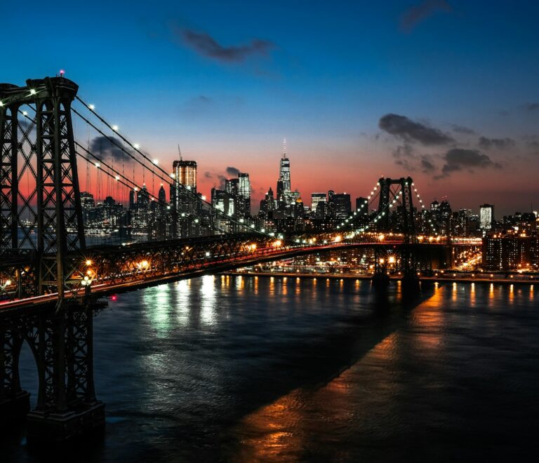Iconic view down Washington Street in DUMBO with 19th-century brick industrial warehouses framing the Manhattan Bridge arch and Empire State Building