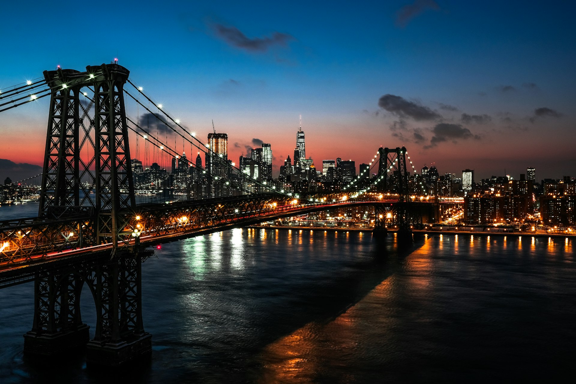 Iconic view down Washington Street in DUMBO with 19th-century brick industrial warehouses framing the Manhattan Bridge arch and Empire State Building