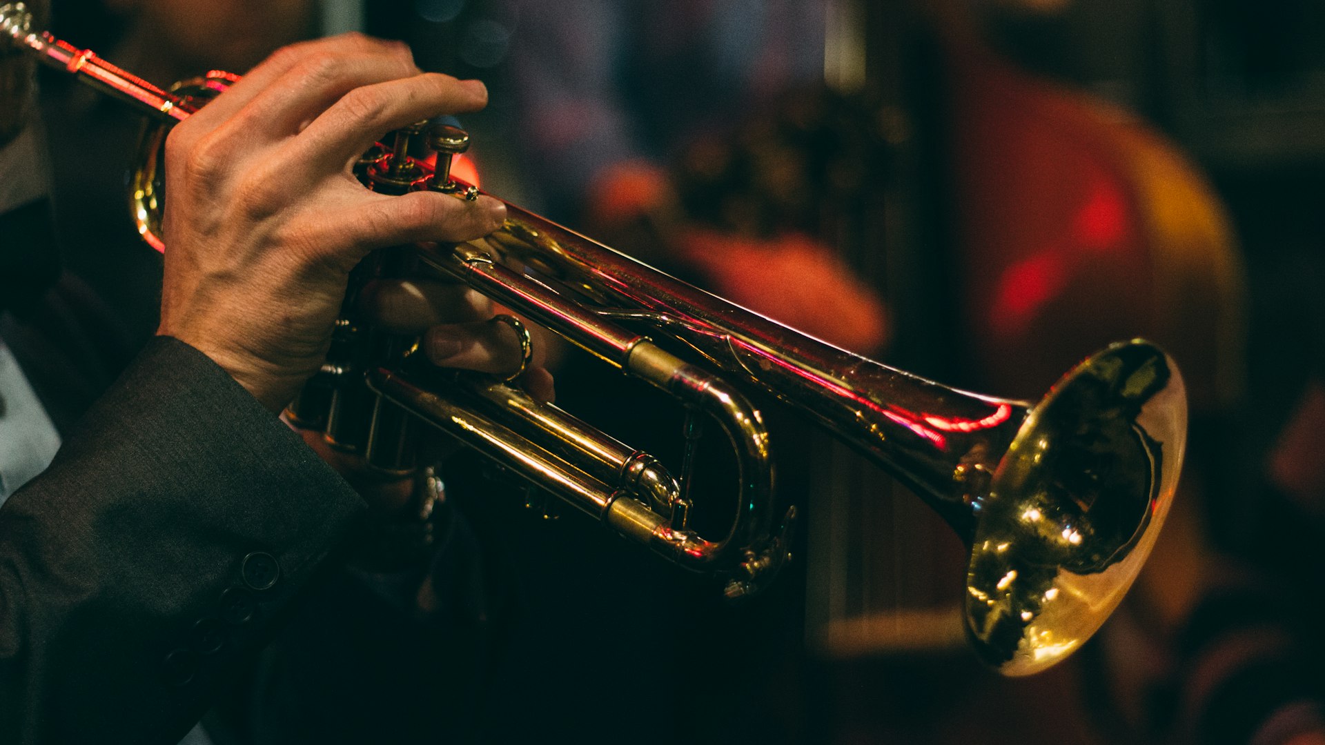 Atmospheric candlelit New York City jazz club with a vintage saxophone player performing on stage before an appreciative audience
