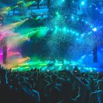 High-energy luxury Manhattan nightclub lounge with VIP bottle service, glowing sparklers, plush velvet banquettes, and dancing crowds
