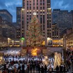 Enchanting winter evening photograph of the Rockefeller Center Christmas tree illuminated with thousands of glowing lights in New York City