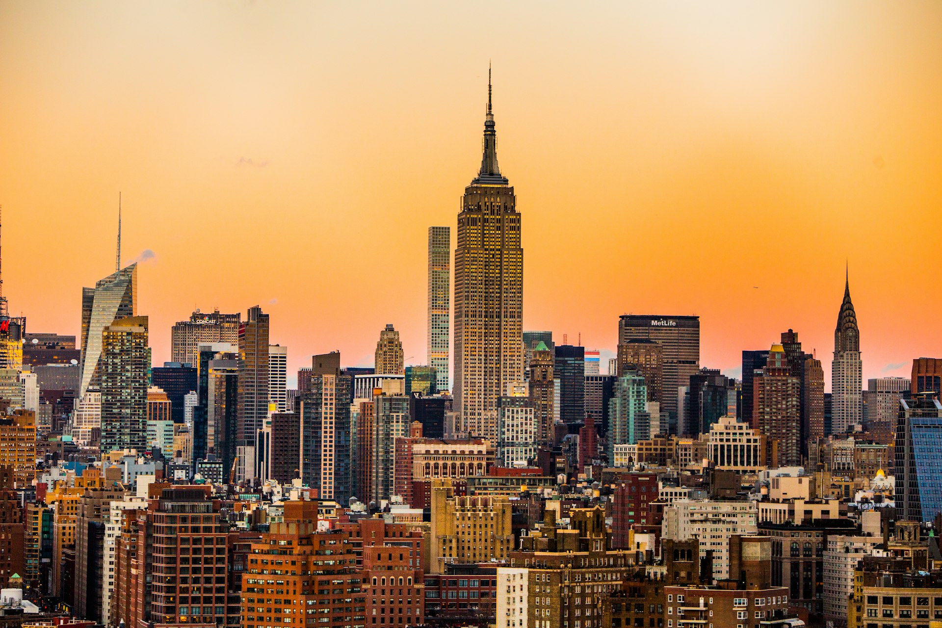 Stylish solo traveler standing confidently amidst the historic architecture and vibrant morning street life of Manhattan