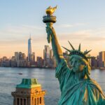 Cinematic golden morning view of the Statue of Liberty in New York Harbor with Lower Manhattan skyline in the distance